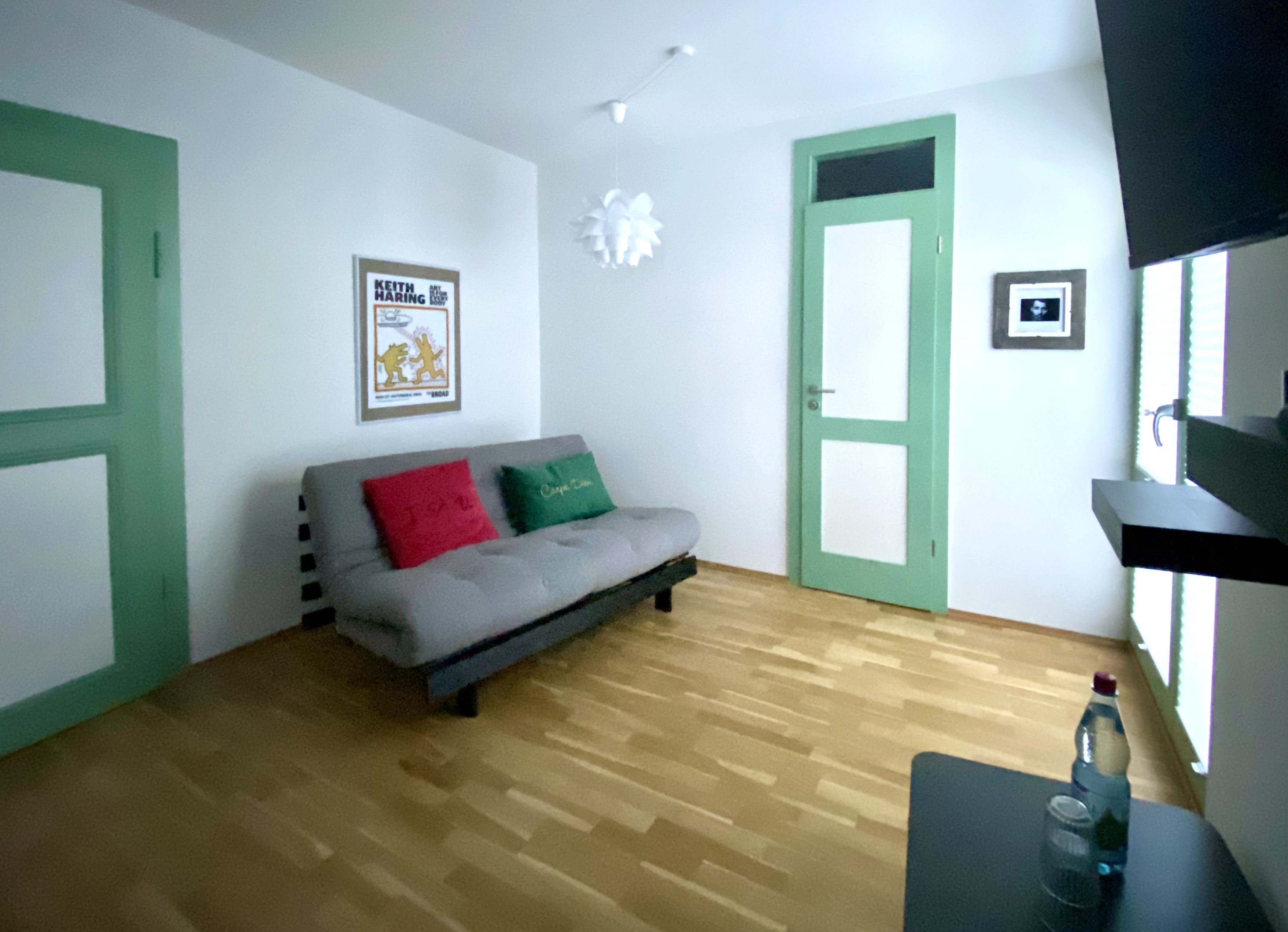 Wohnzimmer mit Schlafsofa und Kunstdruck